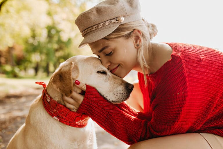 Closeup photo of pretty girl and her dog sitting in autumn the park. Lovely blonde having good time