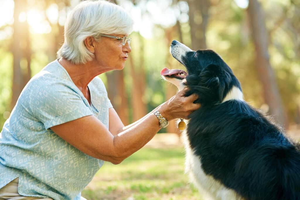 senior woman relaxing park with her dog