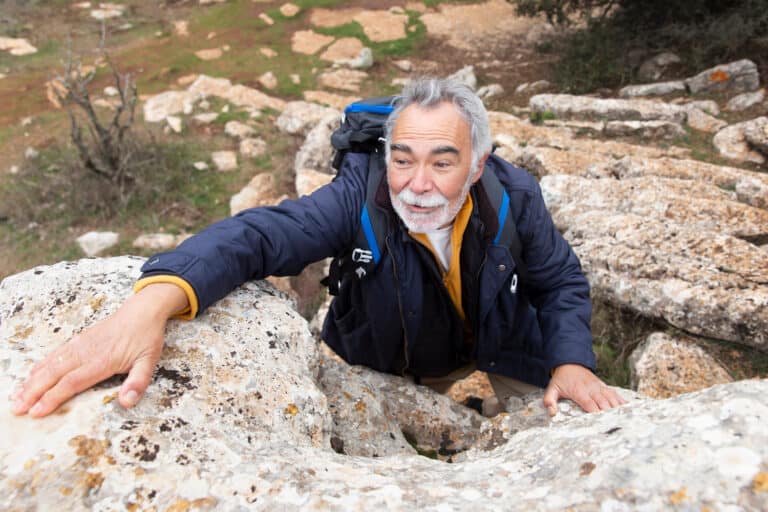 Senior man climbing rock