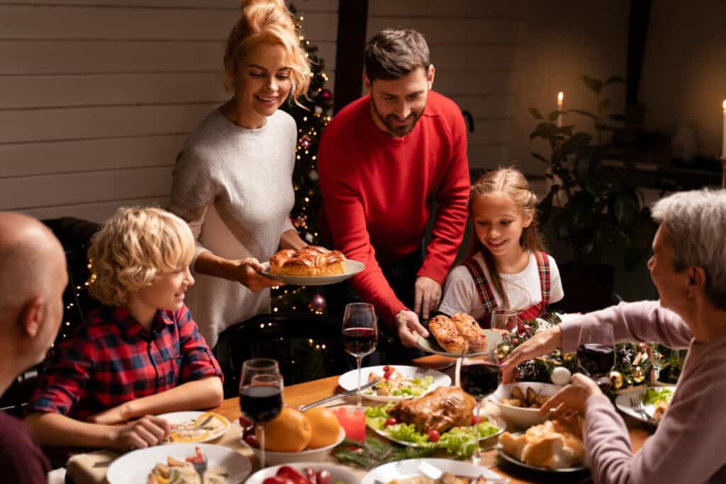 close up of family preparing Christmas dinner table