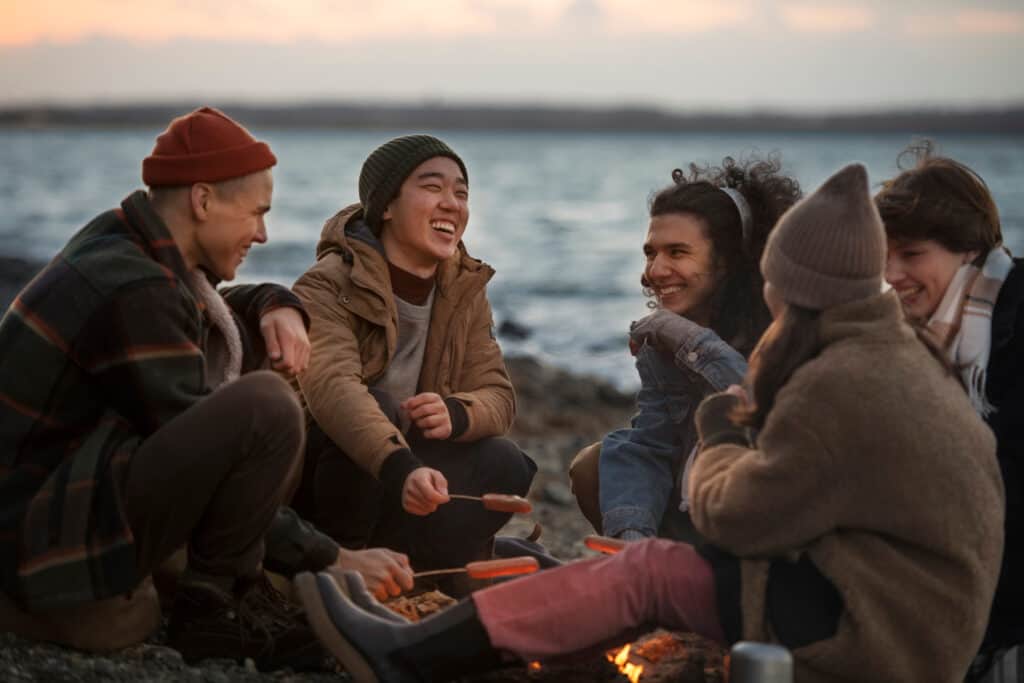 friends sitting together enjoying a beach campfire